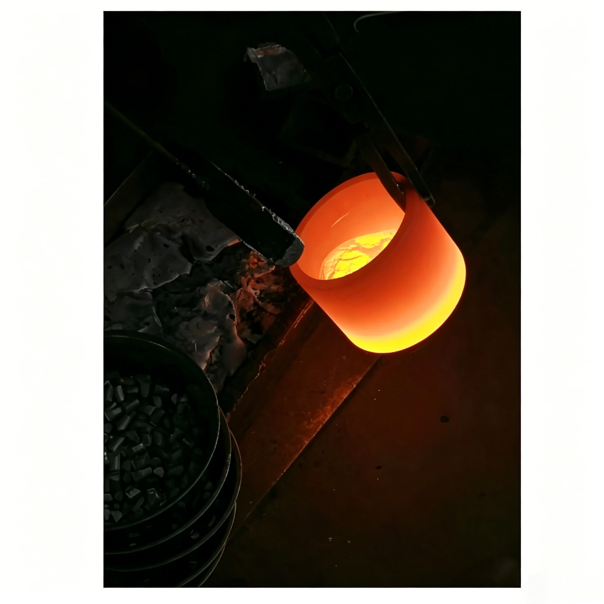 Creuset en graphite brillant contenant de l'aluminium fondu, utilis&eacute; dans le processus de rev&ecirc;tement par &eacute;vaporation sous vide, d&eacute;montrant une excellente stabilit&eacute; thermique et r&eacute;sistance &agrave; la corrosion
